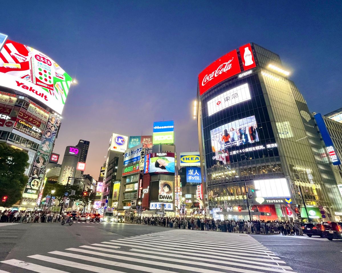 Shibuya Crossing am Abend mit Leuchtreklamen